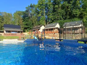 a large swimming pool with a slide and a playground at Domki przy Skarpie in Lądek-Zdrój