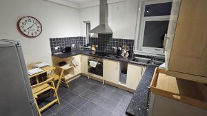 a kitchen with a sink and a clock on the wall at Spacious 2 Bedroom Flat in Coatbridge in Coatbridge +8 photos