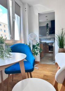 a living room with a blue chair and a table at Apartament Tęczowy Tukan -1 piętro in Kwidzyn