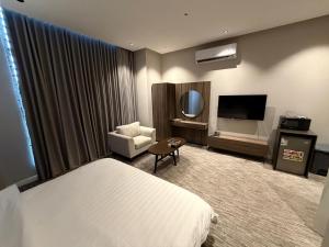 a hotel room with a bed and a television at شقق ثري ستار للشقق المخدومة 5 in Al Kharj