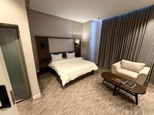 a hotel room with a bed and a chair at شقق ثري ستار للشقق المخدومة 5 in Al Kharj +42 photos