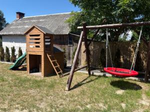 a playground with a swing and a house at Villa Roztocze in Pary