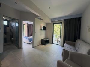 a living room with a couch and a bed at domus hospitality in Vourvourou