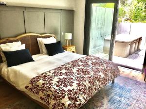 a bedroom with a bed and a balcony with a view at Stunning New Apartment Senningerberg in Niederanven