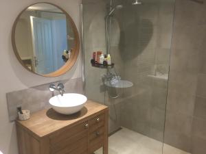 a bathroom with a sink and a shower with a mirror at Stunning New Apartment Senningerberg in Niederanven