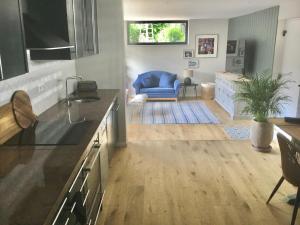a kitchen and living room with a blue couch at Stunning New Apartment Senningerberg in Niederanven