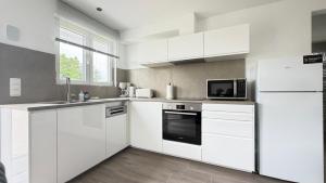 a white kitchen with white cabinets and appliances at L'Annexe in Arlon