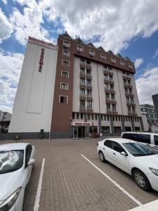 a large building with cars parked in a parking lot at Korkmaz Rezidans in Kayseri