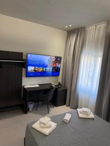 a bedroom with a bed and a desk with a television at Rooms Residence Rubiera in Rubiera