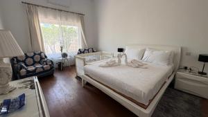 a bedroom with a bed and a chair and a window at Secret Villa - Room Lily in Taʼ Lampuka +45 photos