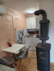 a stove in a kitchen with a table and a table and chairs at Vikendica Vidik in Divčibare