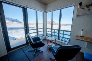 a room with two chairs and large windows at Grásteinn, guesthouse 2 in Grundarfjordur