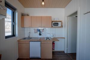 a small kitchen with a sink and a microwave at Grásteinn, guesthouse 2 in Grundarfjordur