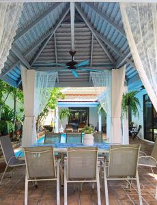 a patio with a table and chairs and a ceiling at 4 Bed Villa Private Pool and BBQ Jomtien Beach in Jomtien Beach