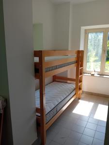 two bunk beds in a room with a window at Planinski dom Hermanov Hram in Log pod Mangartom +3 photos