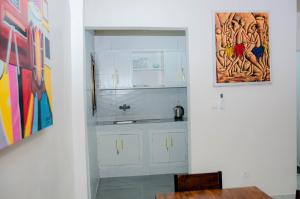 a kitchen with white cabinets and a painting on the wall at Raoul Immobilier JDMK in Brazzaville +49 photos