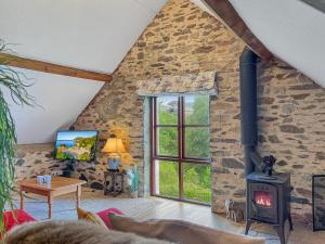 a living room with a stone wall and a wood stove at Norton Cottage Hawkridge in Dulverton