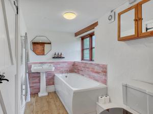 a bathroom with a white tub and a sink at Norton Cottage Hawkridge in Dulverton +44 photos