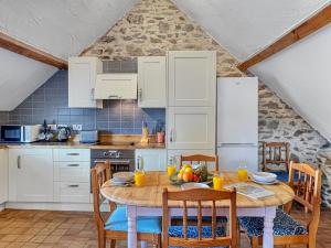 a kitchen with a table and chairs in a kitchen at Norton Cottage Hawkridge in Dulverton