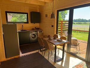 a kitchen and dining room with a table with chairs at Stodoła in Kamień
