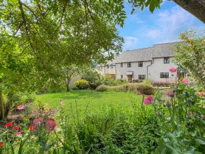 a house with a garden with flowers in the foreground at Ruffles Cottage Dunster in Dunster