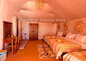 a bedroom with three beds in a room at Amazing Luxury Camp in Merzouga