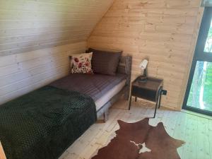 a room with a bed in a wooden cabin at Stodoła in Kamień