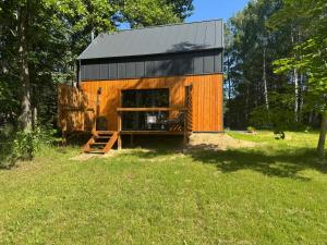 a small orange building with a black roof in a field at Stodoła in Kamień