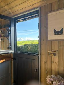 a window in a room with a black cat on the door at Valentine in Longdown