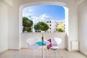 a table and two chairs in a room with a window at Le Stagioni Rooms in Vieste