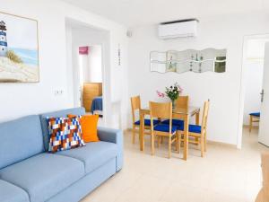a living room with a blue couch and a table at Mediterranean Escape - Sea Views Pool in Malgrat de Mar