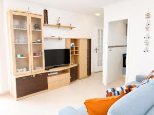 a living room with a tv and a blue couch at Mediterranean Escape - Sea Views Pool in Malgrat de Mar