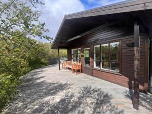 a house with a porch with benches on it at Húsafell holiday homes in Húsafell