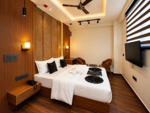 a bedroom with a large bed and a flat screen tv at Casa Grande in Srinagar