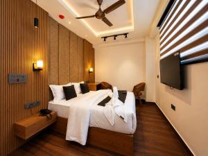 a bedroom with a bed and a flat screen tv at Casa Grande in Srinagar