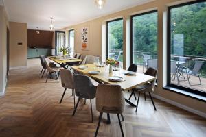 a dining room with tables and chairs and large windows at Residence by Carol&Vladi in Târgu Ocna +49 photos