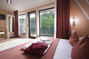 a bedroom with a bed with a large window at Residence by Carol&Vladi in Târgu Ocna