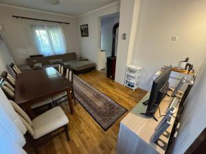 a living room with a dining room table and a television at Vila Ljubinka in Brežđe