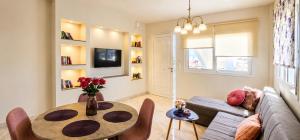 a living room with a table and a couch at Ma Maison Rose in Kremasti
