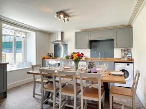 a kitchen with a table with chairs and a sink at Wingate Farm Countisbury in Countisbury