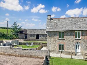 an old stone house with a yard and a patio at Wingate Farm Countisbury in Countisbury