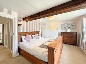 a bedroom with a large bed with a wooden headboard at Wingate Farm Countisbury in Countisbury