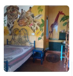 a bedroom with a mural of animals on the wall at Furaha Rena -Kendwa in Kendwa