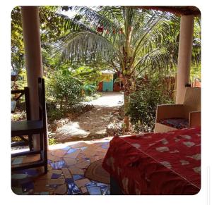 a view of a patio with a table and a palm tree at Furaha Rena -Kendwa in Kendwa