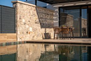 a table and chairs on a patio next to a pool at SoleLuna - The Villas Project in Marmaroto +91 photos