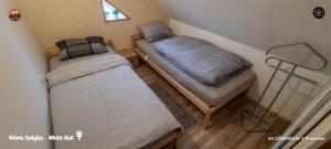 a couple of beds in a small room at Vilimu Sodyba - White Hall in Kriukai