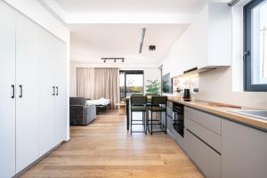 a kitchen with white cabinets and a living room at SoleLuna - The Villas Project in Marmaroto