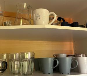 a shelf with cups and glasses on it at Ferienhaus-in-idyllischer-Lage in Inning am Ammersee +8 photos
