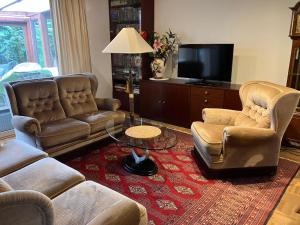 a living room with two couches and a tv at Ferienhaus-in-idyllischer-Lage in Inning am Ammersee