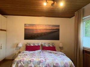 a bedroom with a bed with a painting on the wall at Ferienhaus-in-idyllischer-Lage in Inning am Ammersee